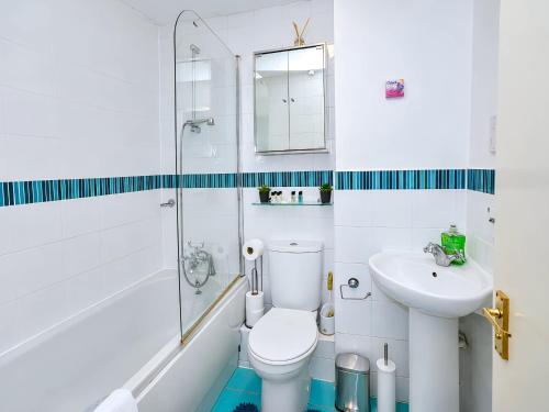 a white bathroom with a toilet and a sink at 2- Bed Contractor Home Near Heathrow in Feltham