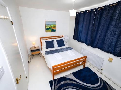 a small bedroom with a bed and a window at 2- Bed Contractor Home Near Heathrow in Feltham