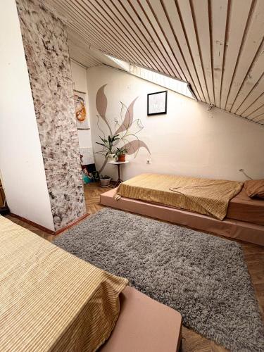 a room with two beds and a stone wall at The Vibe Spot in Podgorica