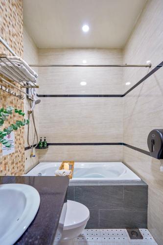 a bathroom with a tub and a toilet and a sink at Cactusland Hotel Tan Binh Near T3 Station in Ho Chi Minh City