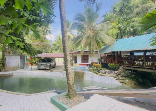 a villa with a swimming pool in front of a house at Merlot in Deniyaya