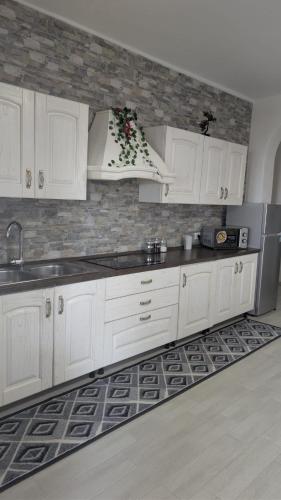 a kitchen with white cabinets and a sink at Casa Enza in Forio d'Ischia