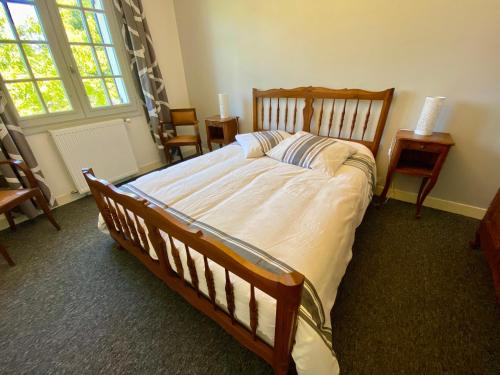 a bedroom with a large bed in a room with chairs at La Rousselie in Montagrier