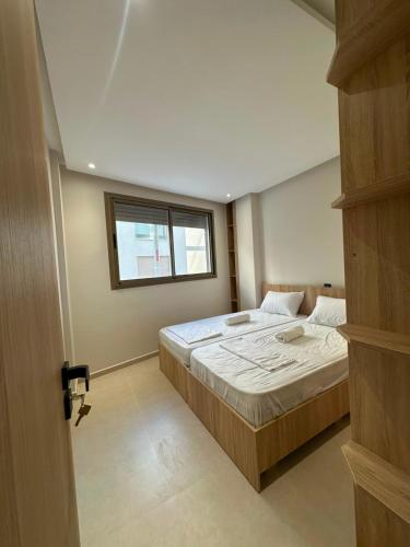 a bedroom with a large bed and a window at Igar Azougagh Immeuble DII in Al Hoceïma