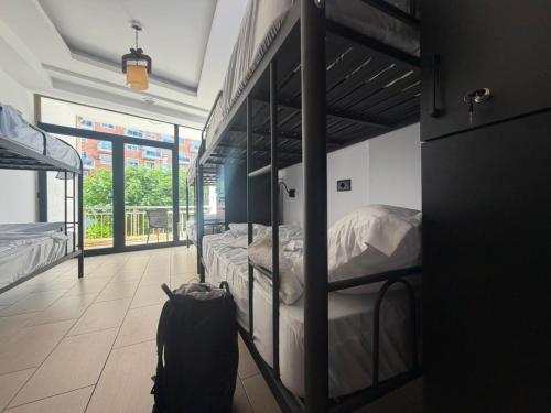 a room with two bunk beds and a backpack at Englishman Hostel Shkoder Backpackers Instant Sleep in Shkodër