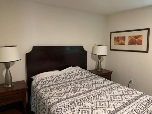 a bedroom with a bed with two lamps on tables at 2Bed 2Bath Lake Front Jewel in Lake Mary