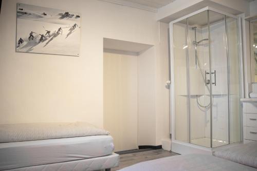 a bathroom with a glass shower and a bed at Bockwirt in Schladming