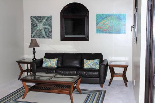 a living room with a black couch and a table at The Meridian at Lighthouse Point in West Bay