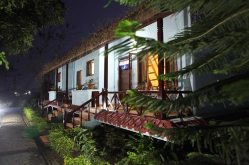 a house with a bench in front of it at night at Chitwan Forest Resort , Chitwan National Park in Sauraha