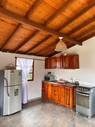 a kitchen with wooden cabinets and a refrigerator at Villa Belén in Guarne