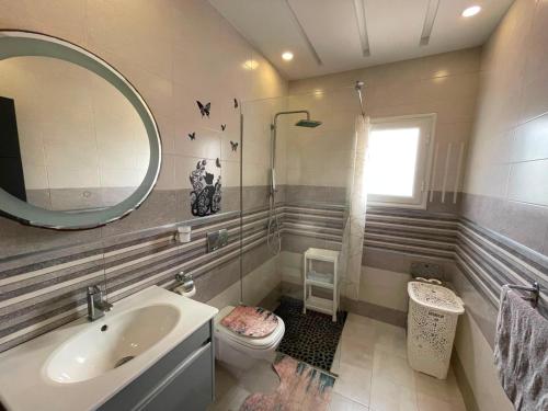 a bathroom with a sink and a toilet and a mirror at Dar ZYED in Houmt Souk
