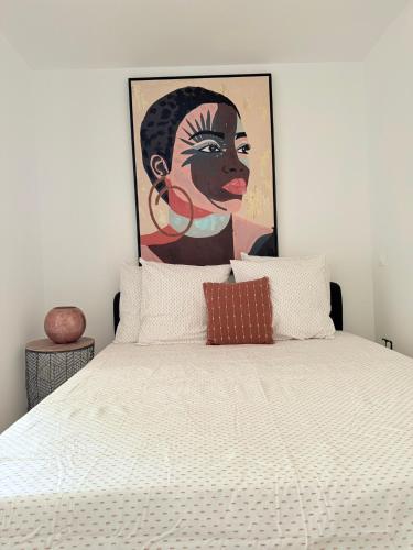 a bedroom with a bed with a painting above it at Heritage Suites- Palais des Papes & Pont d'Avignon- Clim in Avignon