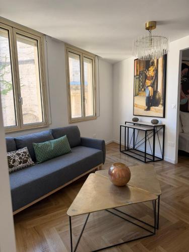 a living room with a blue couch and a table at Heritage Suites- Palais des Papes & Pont d'Avignon- Clim in Avignon