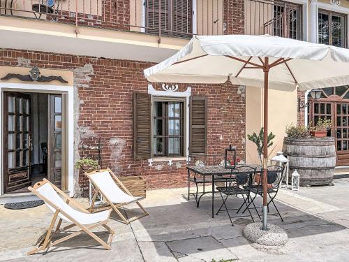 a patio with a table and an umbrella at Apartment Cà Maria-2 by Interhome in Asti