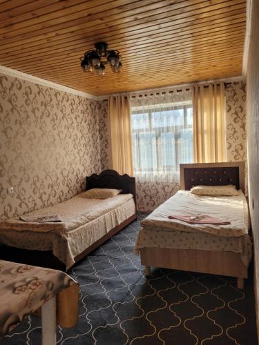 a bedroom with two beds and a window at Hotel Sarytag in Sarytag