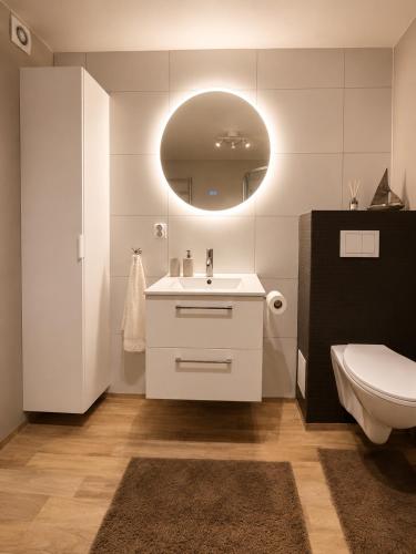 a bathroom with a sink and a toilet and a mirror at Leilighet Preikestolen in Strand