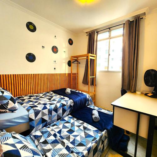 a room with two beds and a table and a window at AP 3 quartos -2min da ARENA MRV e Expominas- BH in Belo Horizonte