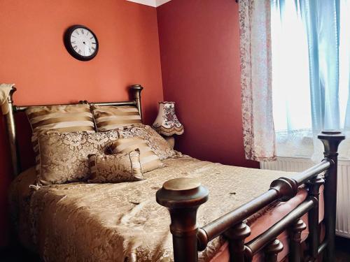 a bedroom with a bed with a clock on the wall at Trnova Ruzica in Trnovac
