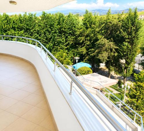 a balcony with a view of a park at Shtepia e Bardhe in Patos