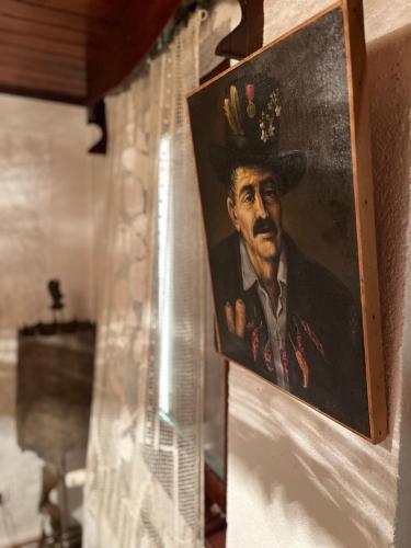 a painting of a man in a hat hanging on a wall at Trnova Ruzica in Trnovac