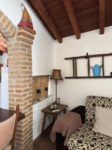 ein Wohnzimmer mit einer gemauerten Säule und einem Tisch in der Unterkunft Casa da Muralha - Avis in Avis