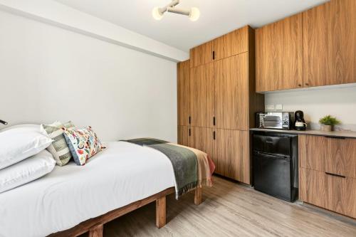 a bedroom with a bed and a kitchen at GuestReady - The Bridge - Wealdstone in London