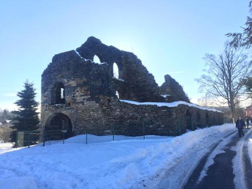 an old stone building on a snow covered road at Apartmán Kovářská u Klínovce in Kovářská