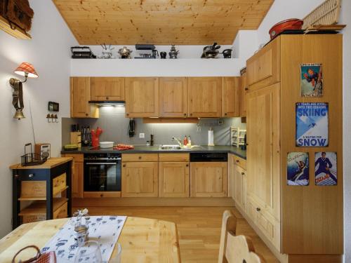 a kitchen with wooden cabinets and a wooden table at Apartment Mon Abri B by Interhome in Les Diablerets