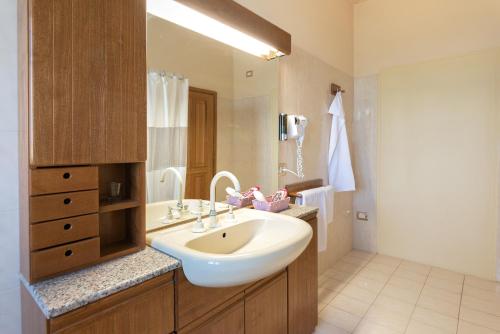 a bathroom with a sink and a large mirror at Il Nido del Falco in Montefalco