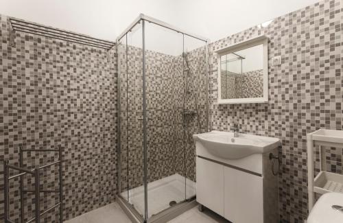 uma casa de banho com um chuveiro, um lavatório e um espelho. em WHome | Fanqueiros Downtown Typical Apartment em Lisboa