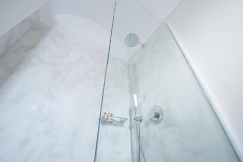a shower stall with a glass shower door at Casasantantonio 18th Century Luxury Mansion in Fira