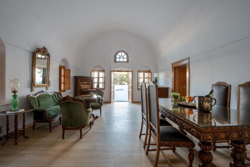 a dining room with a table and chairs at Casasantantonio 18th Century Luxury Mansion in Fira