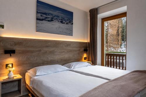a bedroom with a large bed and a window at Hotel Zanella in Peio Fonti