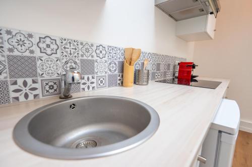 a kitchen counter with a sink in a kitchen at T2 Cosy - Amiens Centre - Wifi in Amiens
