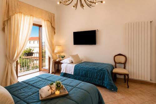 a hotel room with two beds and a window at Maison Vico94 in Vico Equense
