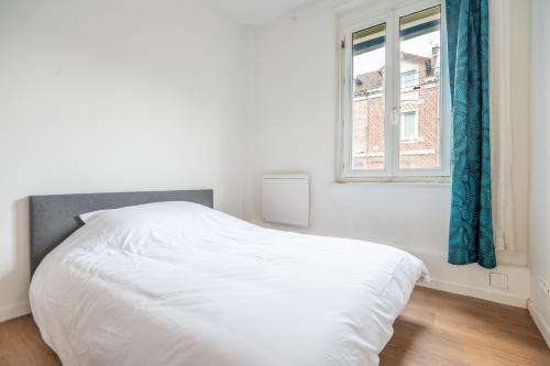 a white bed in a white bedroom with a window at T2 Cosy - Amiens Centre - Wifi in Amiens