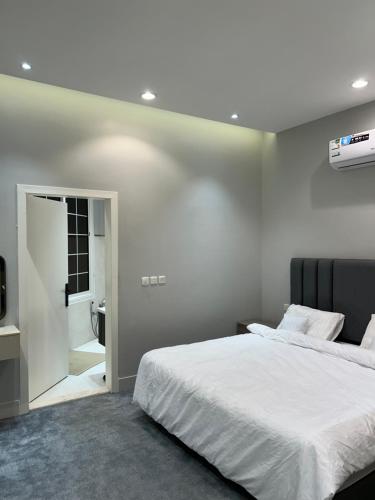 a bedroom with a white bed and a bathroom at The Mountain View in Al Namas in Al Namas