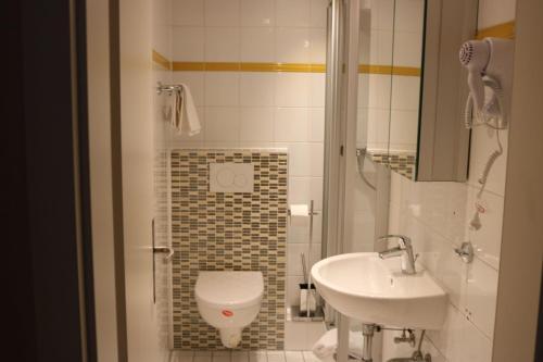 a bathroom with a toilet and a sink at Hotel Paris in Düsseldorf