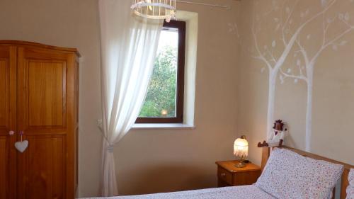 a bedroom with a bed and a window at Agriturismo Al Respiro Nel Bosco in Camporotondo di Fiastrone