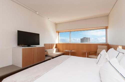 a bedroom with a large bed and a television at Melia Palma Bay in Palma de Mallorca