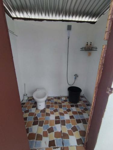 a bathroom with a toilet and a tiled floor at Isla Malaya Tours Campsite in Mantangule Island
