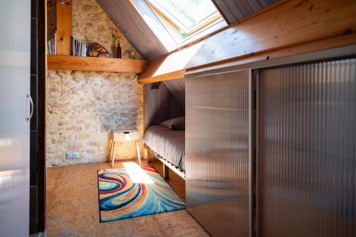 a room with a bed and a closet with a glass door at Domaine de Cantegrel - Gîtes de Charme et Suite Troglodyte en Périgord in Vitrac