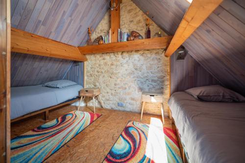 a bedroom with two beds in a room with wooden ceilings at Domaine de Cantegrel - Gîtes de Charme et Suite Troglodyte en Périgord in Vitrac