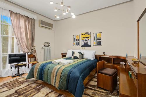 a bedroom with a bed and a desk and a television at Villa Amalia Laconia in Dháfnion