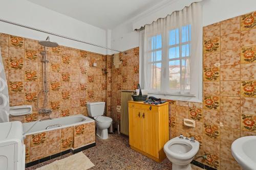 a bathroom with a tub and a toilet and a sink at Villa Amalia Laconia in Dháfnion