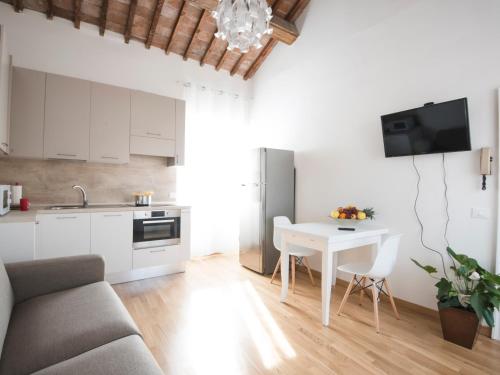 a kitchen and a living room with a table at Italianflat - Palazzo Rizzardi in Verona