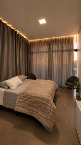 a bedroom with a large bed in front of a window at Sely Suítes in Ametista do Sul