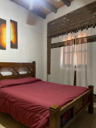 a bedroom with a red bed and a window at Complejo el cordobes in Albardón