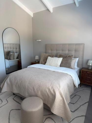 a bedroom with a large bed and a mirror at Cosy Langdown Getaway in Plettenberg Bay