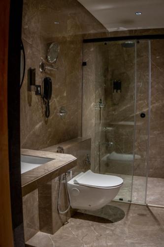 a bathroom with a toilet and a glass shower at Hotel Vintana in Nananpur